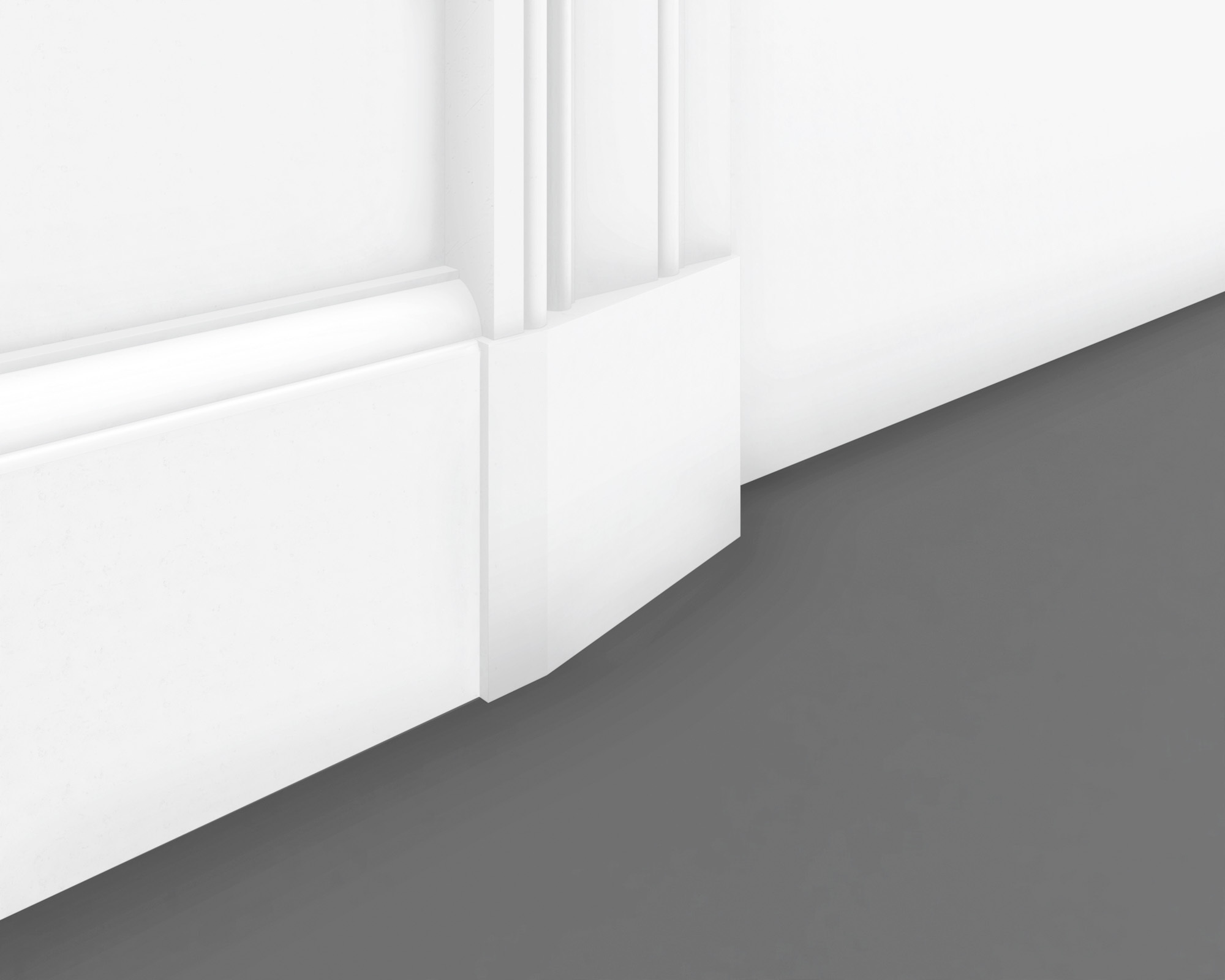 White plinth block connecting fluted door casing with a flat baseboard